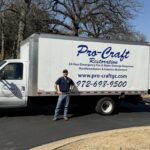 Pro-Craft Restoration technician standing beside a company service truck at a residential property.