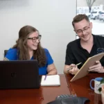 Pro-Craft Restoration office staff reviewing information together at a desk.