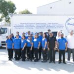Pro-Craft Restoration contents team posing in front of branded service trucks.