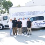 Pro-Craft Restoration construction team standing together in front of company trucks.